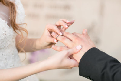 wedding rings and hands of bride and groom. young wedding couple at ceremony. matrimony. man and woman in love. two happy people celebrating becoming family