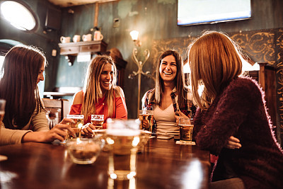 people talking indoors in a pub with the beers