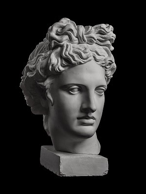 Gypsum statue of Apollo's head on a black background