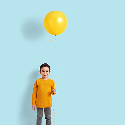 Cute child holding a yellow balloon
