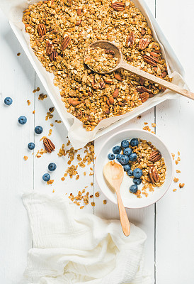 Oat granola with pecan nuts, yogurt and blueberry in bowl
