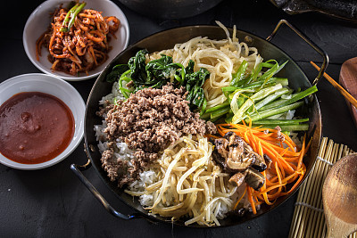 BI Bim Bap, Rice with Mixed Vegetables, top view with Hot Sauce in Cast Iron Pot