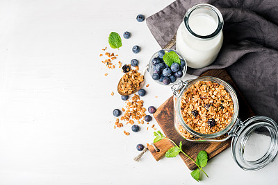 Healthy breakfast ingrediens. Homemade granola in open glass jar, milk