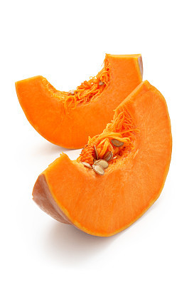 Two slices of pumpkin with the seeds still in