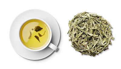 Cup pf Japanese bancha green tea and leaves overhead