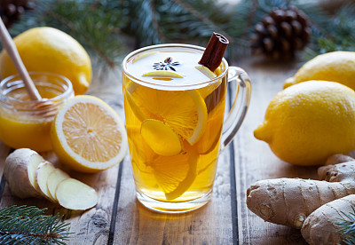 Cup of green natural tea with ginger, lemon and honey on wooden vintage background. Healthy drink.