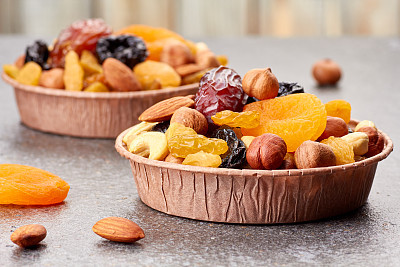 Paper forms with mix of dried fruits and nuts over stone background