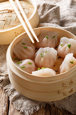 cooked dumplings inside of bamboo steamer. vertical
