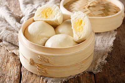 Cantonese steamed custard buns closeup in a bamboo basket. horizontal