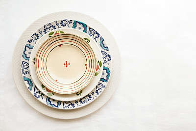 Stack of empty ceramic plates isolated on white background with copy space