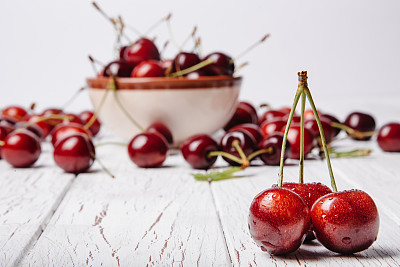 Cherries on wooden table with water drops macro background