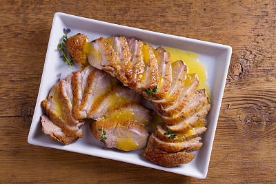 Duck breast with orange sauce on white plate. Duck breast fillet steak.