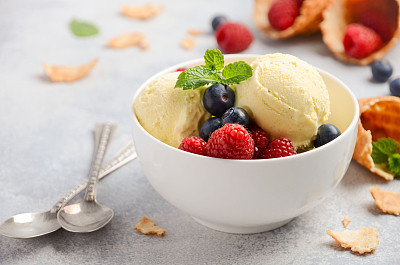 Vanilla ice cream with fresh berries on concrete background