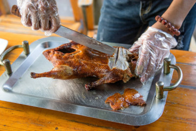 Cook cut up a juicy duck Peking, beautiful, bright and tasty dish that is ready to supply the cook.