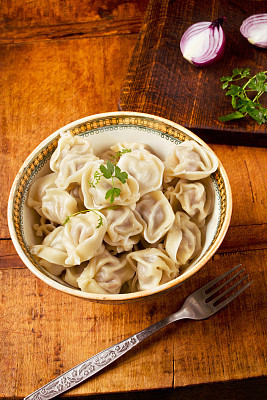 Dumplings in vintage bowl on wooden table