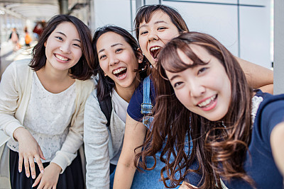 Japanese friends taking a selfie in the station