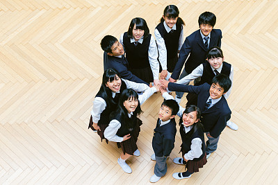 Overhead view of high school students joining hands