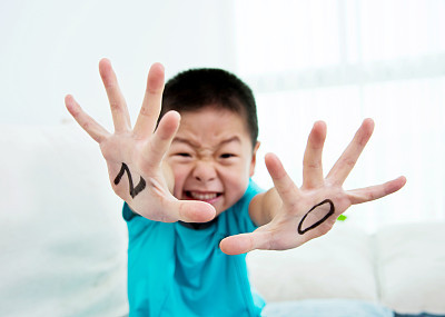 Asian boy makes a stop gesture
