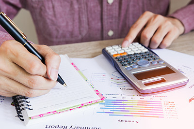 Close up people with calculator counting making