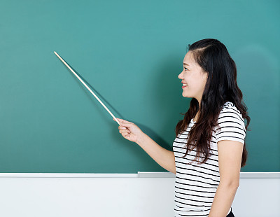 Female teacher pointing to chalkboard