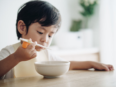 Smiling little boy eating on high chair