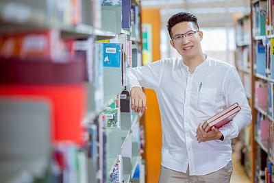 Portrait attractive  Asian man smiling in the library room,Man people lifestyle and education concept