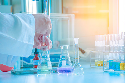 Scientist dropping sample in flask