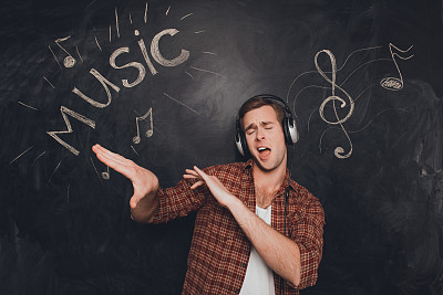 Music fan listening music in headphones and dancing