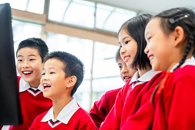 Cheerful students learning computer in lab