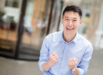 Excited Asian business man celebrating at the office