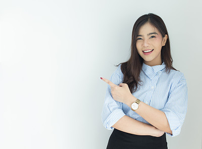 Portrait of young asian business woman pointing up over white background