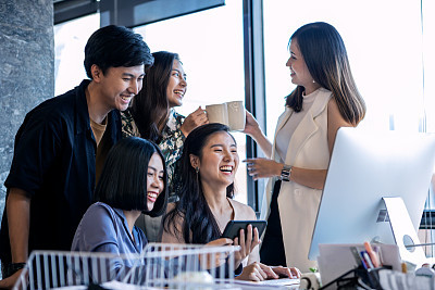 Groups Of Young Asian Business People Happily Coworking Together In The Office