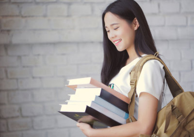Asian students holding books at university