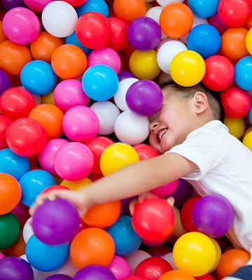 Young boy playing in colorful ball pit