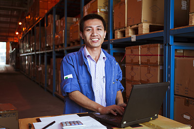 Portrait of Warehouse Businessman with Laptop