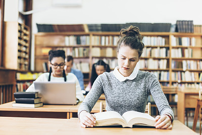 Female student studying for exam at library