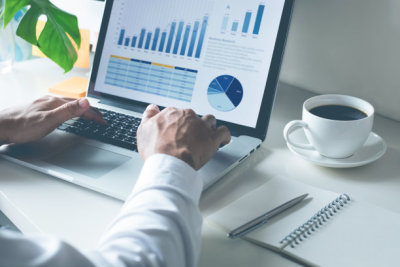 Young businessman typing computer laptop with graph chart