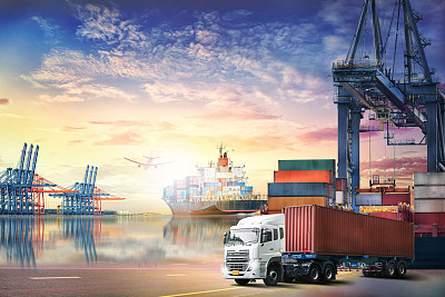 Logistics import export background and transport industry of Container truck and Cargo ship with working crane bridge in shipyard at sunset sky