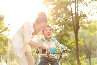 Mom taught his son in the park riding a bike