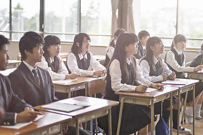 Japanese students listening to the teacher in the classroom