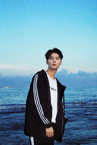 服饰系列写实模特穿着黑色黑白三道杠外套在海边的时尚摆拍