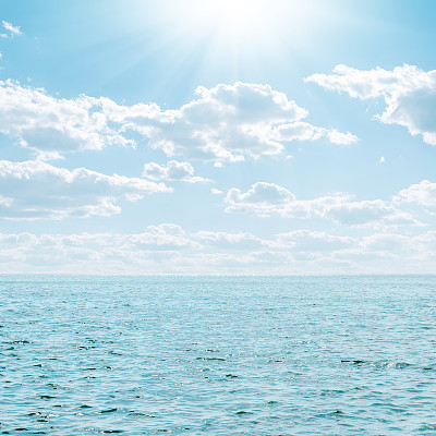 blue sea and sky with clouds and sun