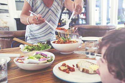 Mother serving food at the table.