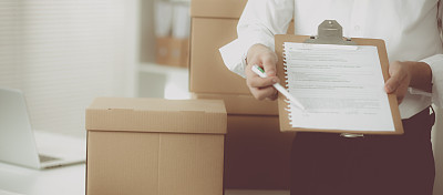 Delivery man with  parcel and a tablet standing in offic