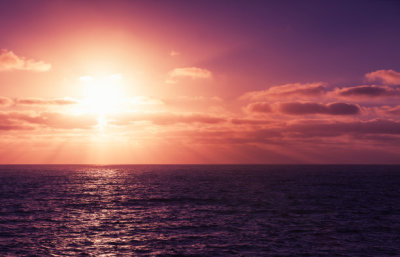 Seascape with sun in dramatic cloudy sky