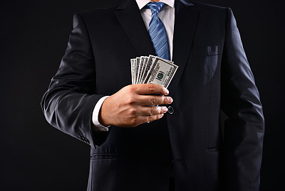 Businessman showing a stuck of money