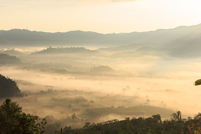 The sun rises behind the mountain in the morning.