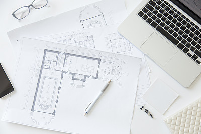 Top view of a working desk with an architect drawing