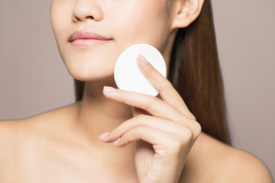 Young woman removing makeup. Skin care concept.