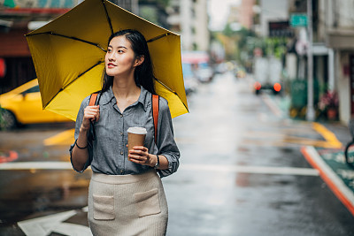 Lady with yellow umbrella on the streets of Taipei